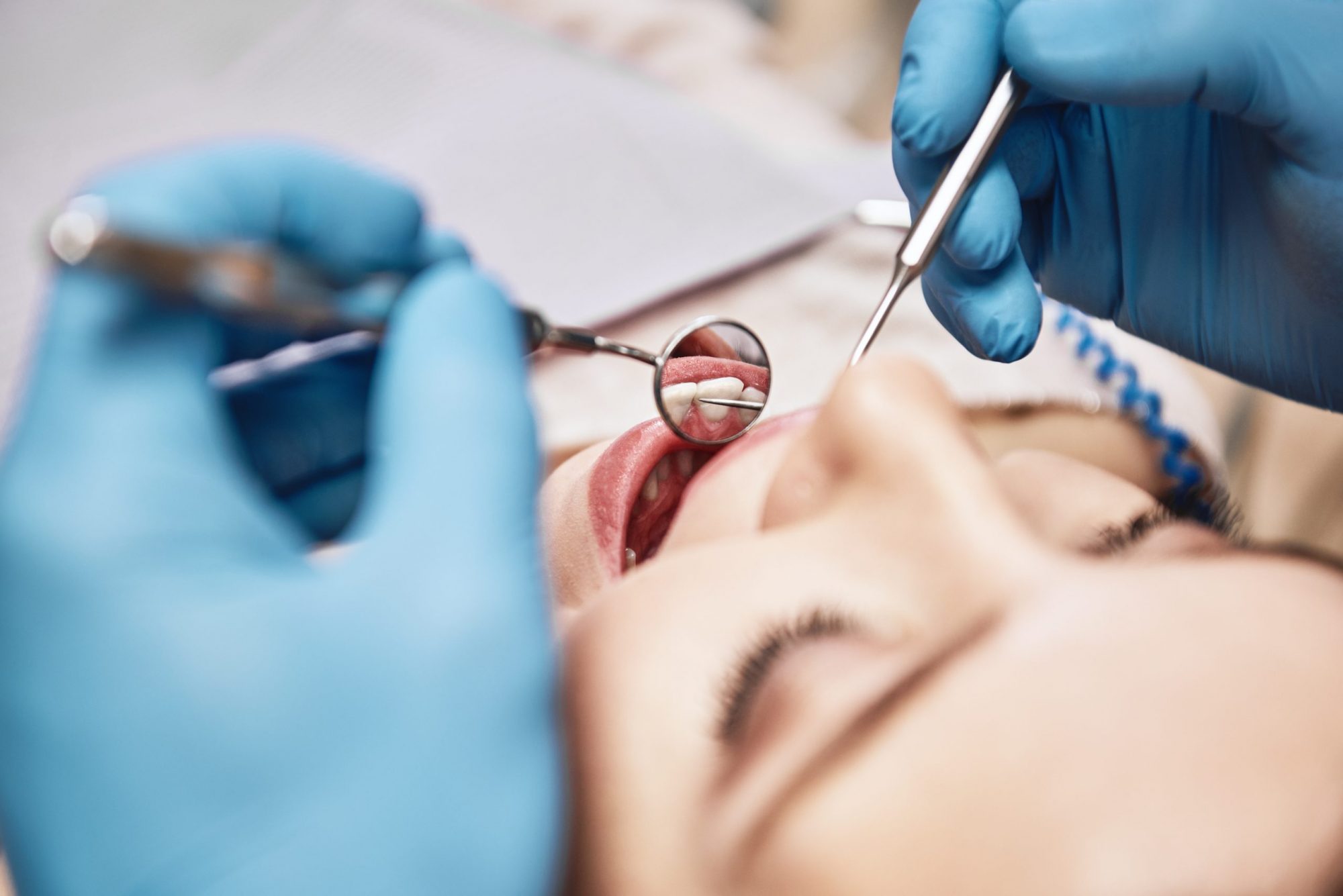 Advanced Medicine, Trusted Care. Attractive woman at the dental office. Dentist examining patient’s teeth in clinic.